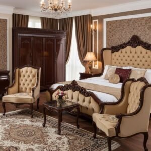 Luxurious master bedroom with dark wood carved furniture, tufted beige headboard, and matching chairs, chandelier, and ornate wallpapered walls.